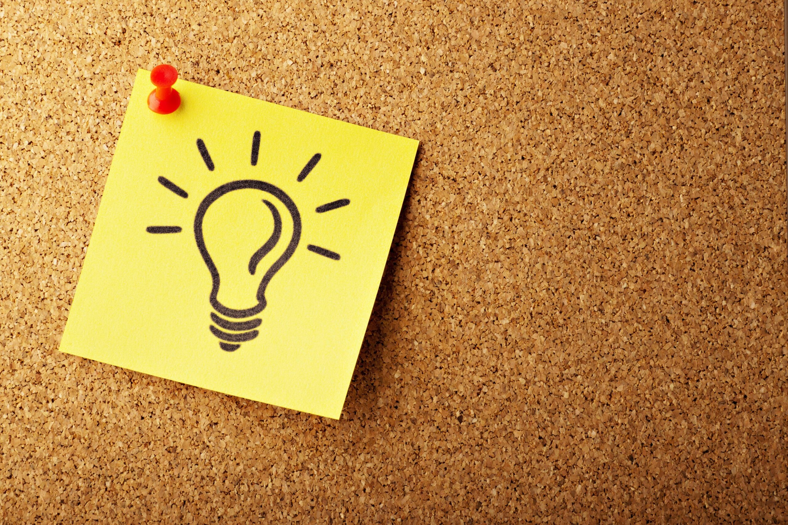 image of a corkboard with a sticky note of a light bulb.